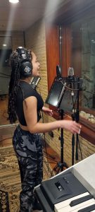 Cassidy(student) recording vocals for a cool rock pop track